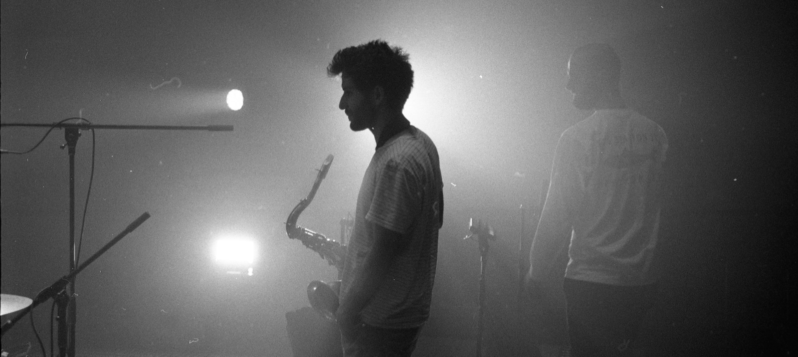 Thibault Barillon on stage with a saxophone, backlit through haze